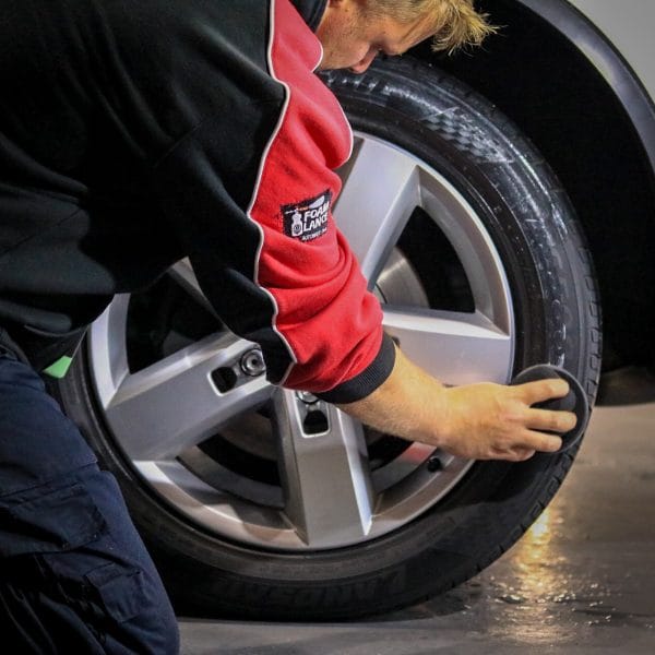 man cleaning tyre