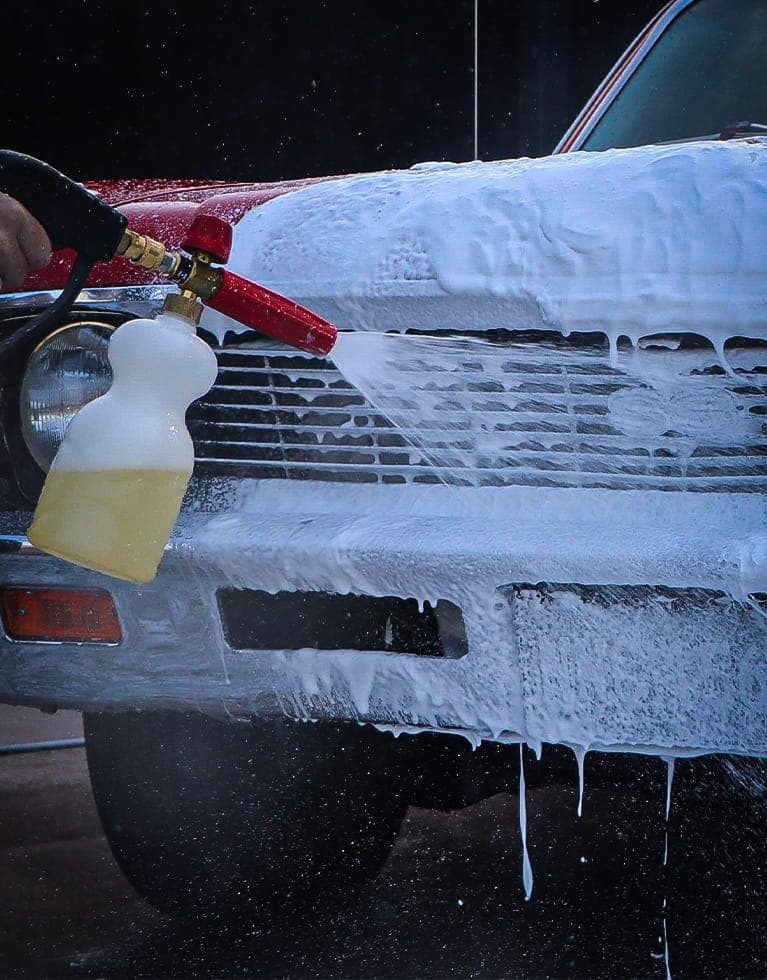 applying snow foam to a classic car