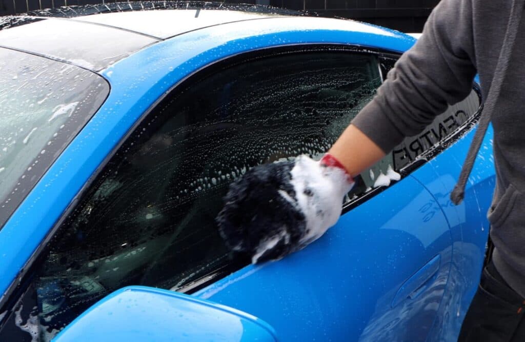 using a mitt to wash a car